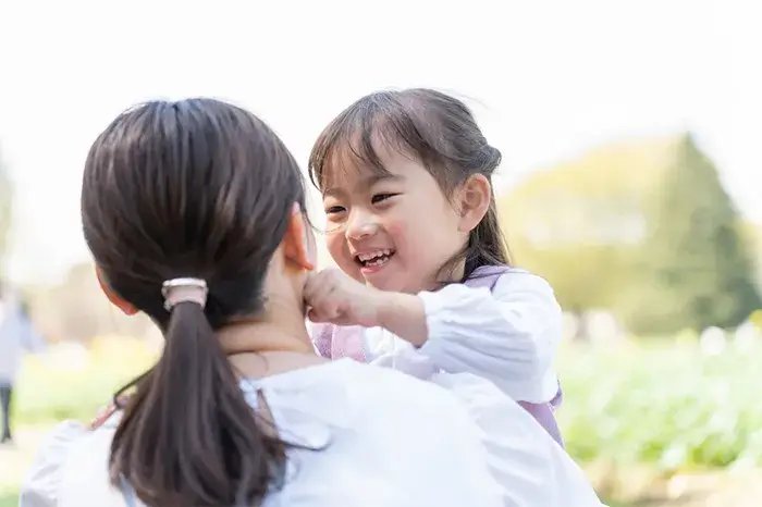 笑顔で母親と触れ合う子供。歯並びの良し悪しが周囲に与える印象と将来のリスクを解説